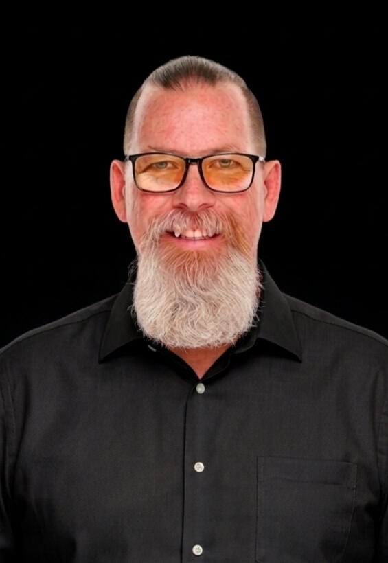 Photo of Brad Bowden. Black Rimmed Glasses. Majestic blonde goatee. Slick back hair pulled into pony tail